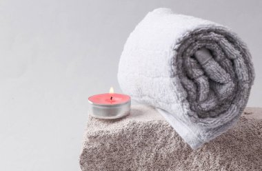 Spa salon, relaxation concept. Aromatherapy. Towel with scented candle on gray background