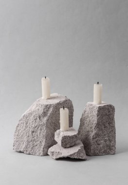Abstract minimalistic scene with candles on stones.