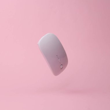 Modern wireless pc mouse flying in antigravity on pink background with shadow. Levitation object in the air. Computer techologies concept. Creative minimal layout