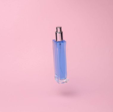Perfume bottle flying in antigravity on pink background with shadow. Levitation object in the air. Beauty and fashion concept. creative minimalist layout