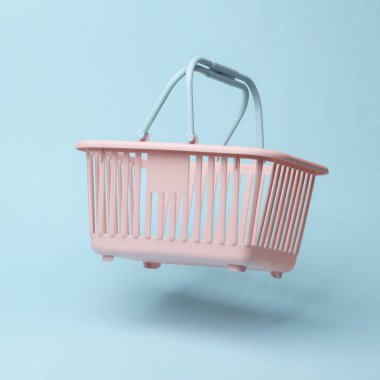 Supermarket basket flying in antigravity on blue background with shadow. Levitation object in the air. Shopping, sale concept. Creative minimalist layout