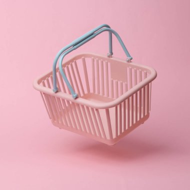 Supermarket basket flying in antigravity on pink background with shadow. Levitation object in the air. Shopping, sale concept. Creative minimalist layout