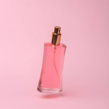 Perfume bottle with pink liquid flying in antigravity on pink background with shadow. Levitation object in the air. Beauty and fashion concept. creative minimalist layout