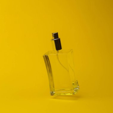 Sarı sıvılı parfüm şişesi, sarı arka planda gölgeli anti yerçekiminde uçuyor. Havada yükselme nesnesi var. Güzellik ve moda konsepti. yaratıcı minimalist yerleşim