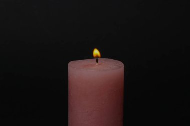 Flaming candle on a black background