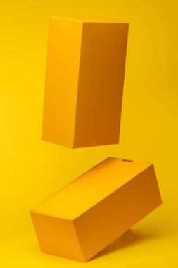Two Yellow boxes mockup flying in antigravity on yellow background with shadow. Levitation object in the air. Creative minimal layout