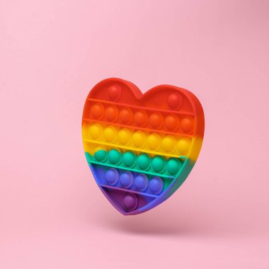 Antistress sensory pop it toy flying in antigravity on pink background with shadow. Levitation object in the air. Creative minimal layout