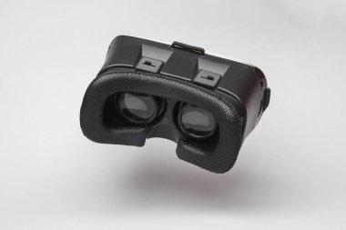 Virtual reality helmet (vr glasses) flying in antigravity on gray background with shadow. Levitation object in the air. Creative minimal layout