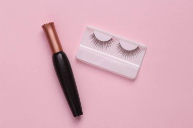 Maskaranın pembe arka planında takma kirpikleri var.