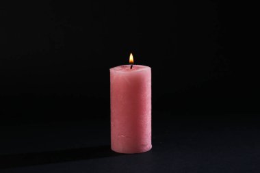 Siyah arka planda yanan mum.