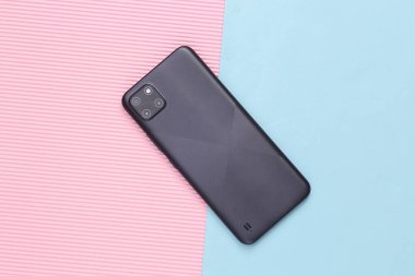 Pembe mavi pastel arka planda akıllı telefonun arka plan görüntüsü. Modern aygıt