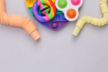 Gri arka planda duyusal stres önleyici oyuncaklar. Boşluğu kopyala