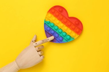 El dokun, anti-stres oyuncağını sarı arka plana koy.