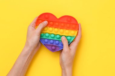 Eller birbirine değdiğinde sarı arka plandaki anti-stres oyuncağını patlat.