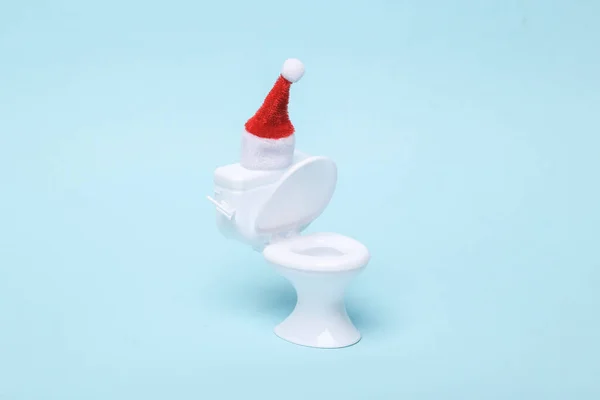 Figur Einer Mini Toilette Mit Weihnachtsmütze Auf Blauem Hintergrund Frohe — Stockfoto
