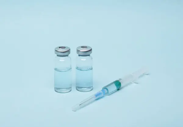 Σύριγγα Δύο Φιαλίδια Υγρού Εμβολίου Μπλε Φόντο — Φωτογραφία Αρχείου
