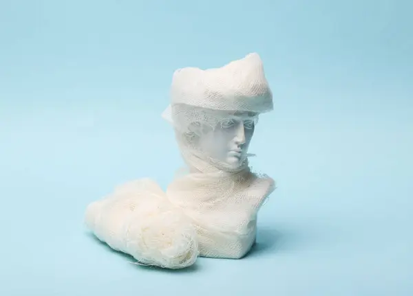 Bust of David wrapped in bandage on a blue background
