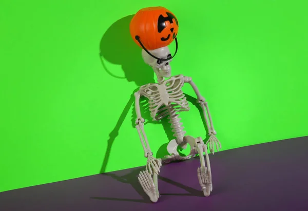 Esqueleto Com Abóbora Balde Halloween Para Doces Fundo Roxo Verde — Fotografia de Stock