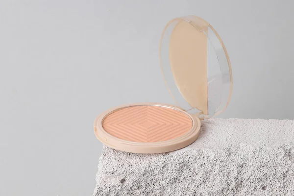 Natural cosmetic. Beauty products. Powder box on stone podium, gray background. Product photo. Abstract composition. Natural showcase