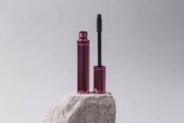 Natural cosmetic. Beauty products. Mascara tube on stone podium, gray background. Product photo. Abstract composition. Natural showcase