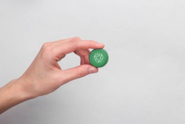 Gri arka planda dairesel geri dönüşüm sembolü olan plastik şişe kapağı. Yuvarlak geri dönüşüm, eko kavramı