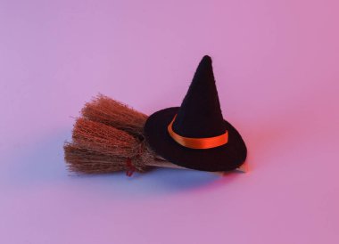 Witch brooms and hat in neon light. Halloween concept