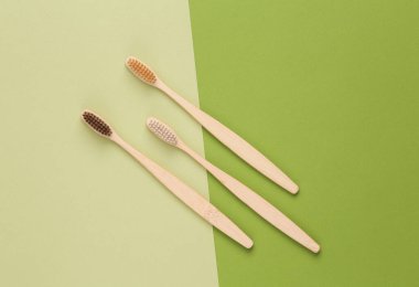 Bamboo toothbrushes on a green background. Eco Products, environmentally friendly, dental care