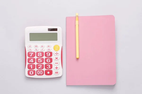 Calculator Met Een Roze Notitieboekje Een Grijze Achtergrond Bovenaanzicht — Stockfoto