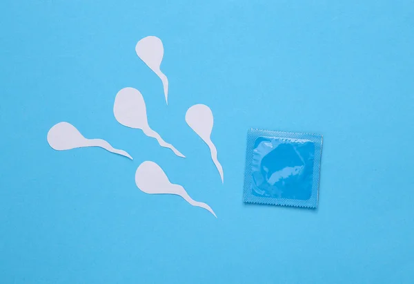 避孕套包和蓝色背景的精子 顶部视图 — 图库照片