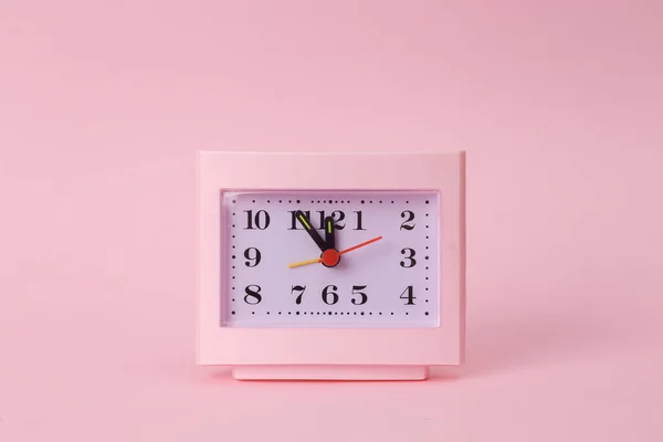 粉色背景上的方桌钟 — 图库照片