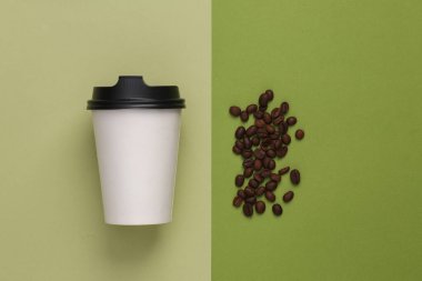 Mockup Blank Take Away Coffee Cup with coffee beans on green background