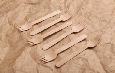 Set of wooden spoons on crumpled craft paper background. Zero waste simple creative concept. Trendy wooden eco things. Top view, Flat lay