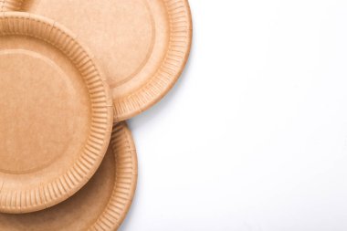 Eco products. No plastic. Zero waste. Craft disposable round plates on white background. Natural materials. Top view. Copy space