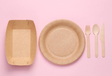 Set of wooden fork, knife and spoon, plates on purple pink background. Zero waste simple creative concept. Trendy wooden eco things. Top view, Flat lay