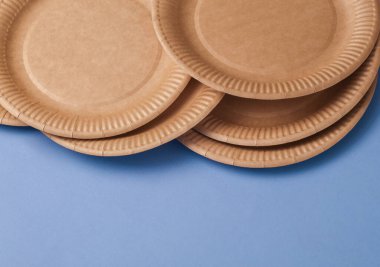 Eco cardboard craft round plates on a blue background. Copy space