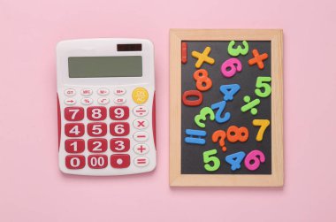 Education concept. Maths. Calculator and chalk board with plastic magnetic numbers on pink background