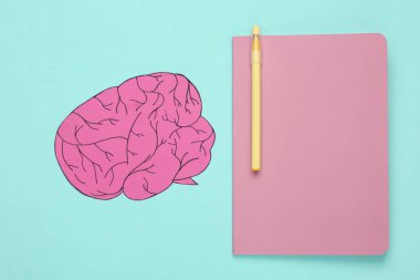 Education concept. Notepad with paper brain on blue background. Top view