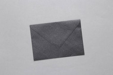Black envelope with glitter on a gray background