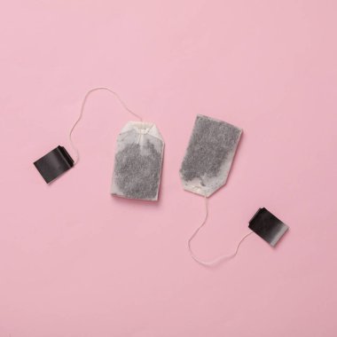Two tea bags on a pink background. Top view clipart