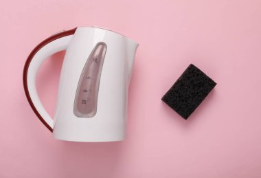 Pembe arka planda süngeri olan elektrikli su ısıtıcısı. Su temizleme, temiz su konsepti.