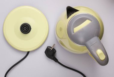 Gri arka planda plastik elektrikli su ısıtıcısı. Üst görünüm
