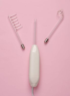 Pembe arka planda yerel darsonvalizasyon için bir cihaz. Sivilce tedavisi, sorunlu deri. Üst Manzara. Düz konum