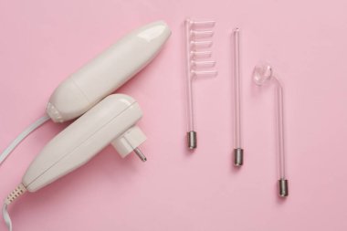 Pembe arka planda yerel darsonvalizasyon için bir cihaz. Sivilce tedavisi, sorunlu deri. Üst Manzara. Düz konum