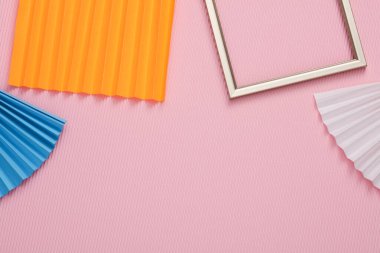 Pembe arka planda kağıt yelpaze olan altın çerçeve. Soyut geometrik arkaplan. Boşluğu kopyala