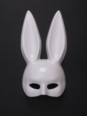 Siyah arka plandaki bir seks dükkanından uzun kulaklı beyaz tavşan maskesi.