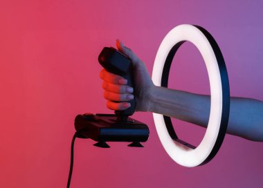 Kadının eli, kırmızı mavi neon eğimli ışıkta eski joystick 'i kurşun halka lambanın içinden tutuyor. Yaratıcı fikir.