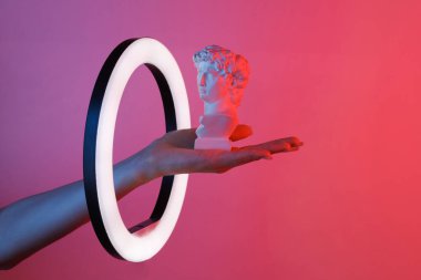 Kadının eli, David 'i kırmızı mavi neon ışık altında kurşun halkalı lambayı bükerek tutuyor. Yaratıcı fikir.