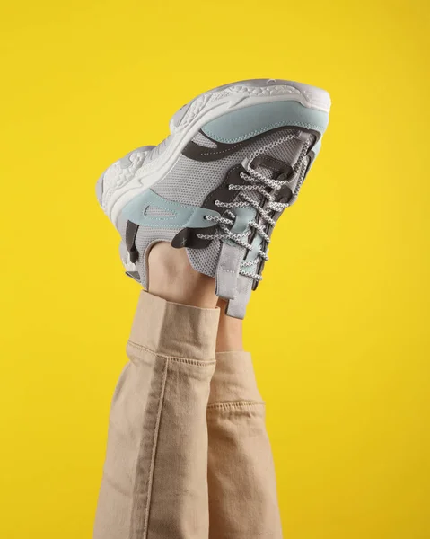 Kvinnors Ben Trendiga Sneakers Med Massiva Sulor Gul Bakgrund Modebild — Stockfoto