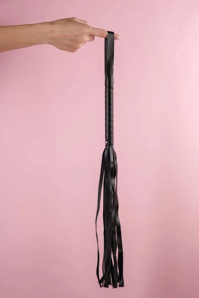 Keze Egy Bőrkorbácsot Tart Rózsaszín Alapon Bdsm Kiegészítők Uralkodás Szex — Stock Fotó