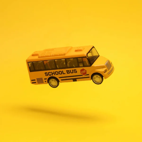 Miniature Bus Scolaire Lévite Sur Fond Jaune Avec Une Ombre — Photo